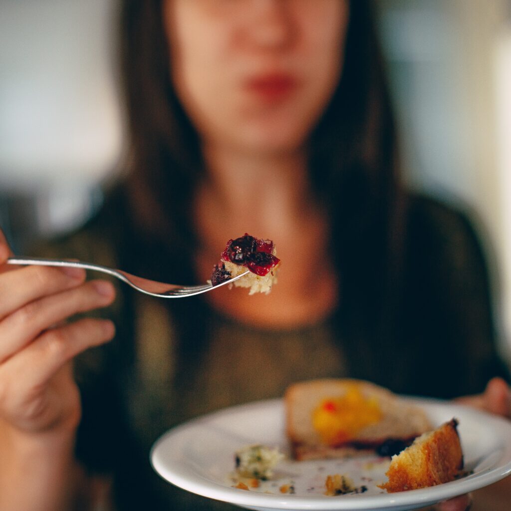 Woman holding a bite of food on a fork